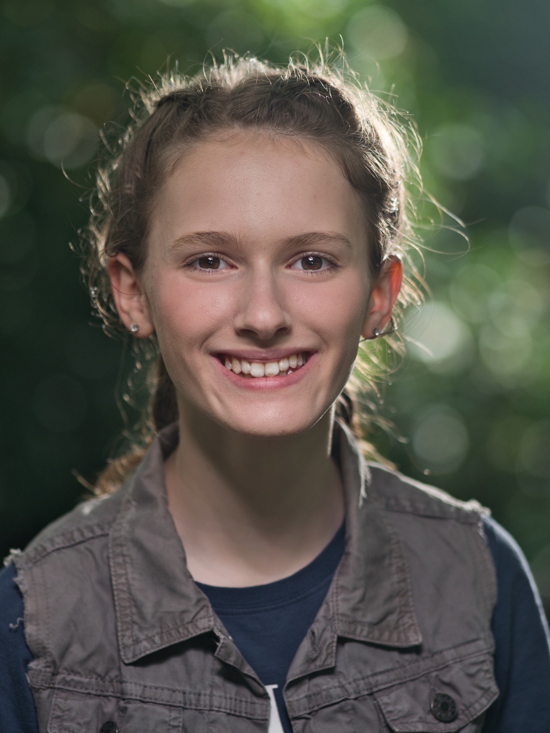 Jeune fille souriante avec un fond flou et lumineux.