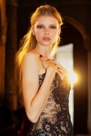 Modèle en robe élégante, lumière douce, regard intense, pose assumée.